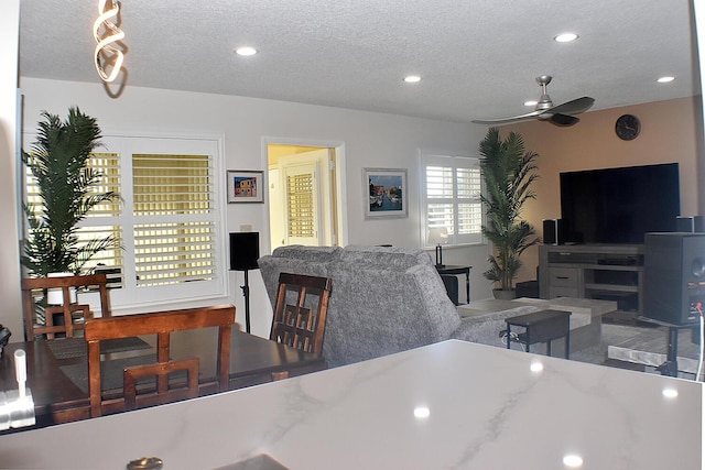 living room featuring a textured ceiling, a ceiling fan, and recessed lighting