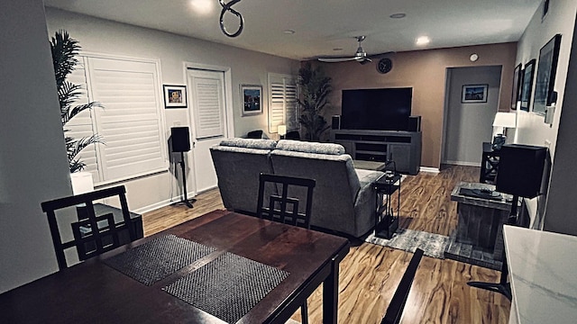 dining space with baseboards, visible vents, a ceiling fan, and wood finished floors