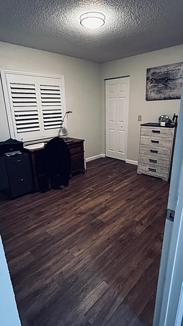 home office featuring a textured ceiling, wood finished floors, and baseboards