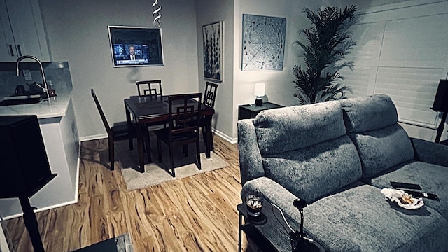 dining space featuring light wood-style flooring and baseboards