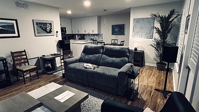 living room with visible vents, baseboards, and wood finished floors