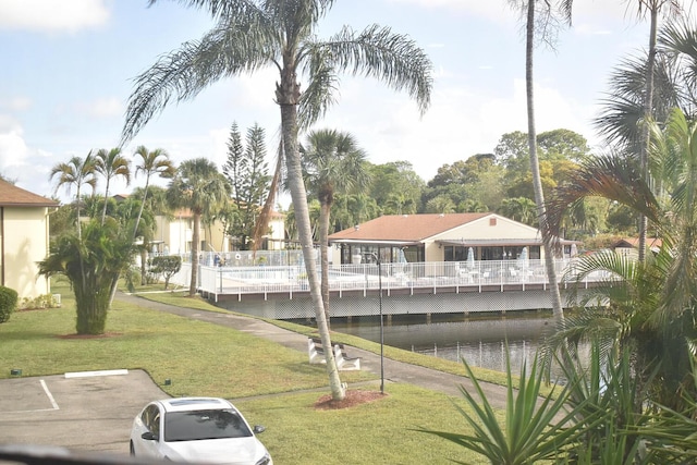 view of property's community with uncovered parking and a yard