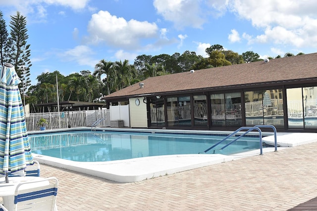 community pool featuring fence and a patio