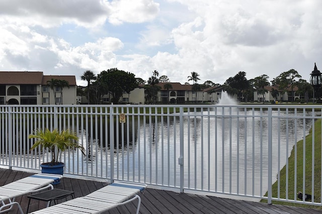 wooden terrace with a water view and a residential view