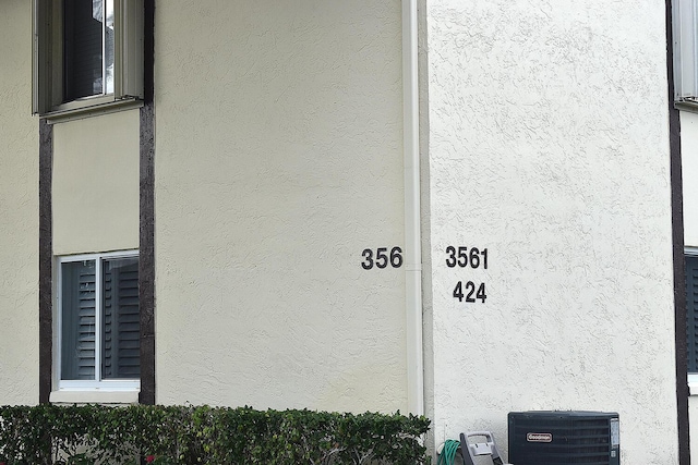 exterior details with central AC and stucco siding