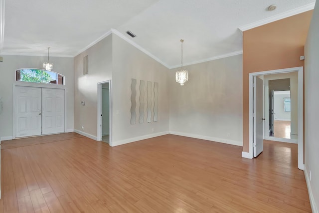 entryway with light hardwood / wood-style floors, crown molding, high vaulted ceiling, and a chandelier