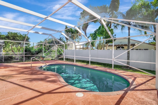 view of pool with a patio and glass enclosure