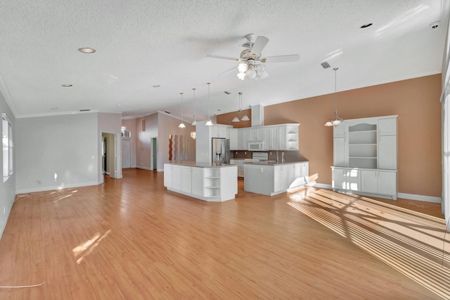 unfurnished living room with ceiling fan, light wood-type flooring, a textured ceiling, lofted ceiling, and ornamental molding