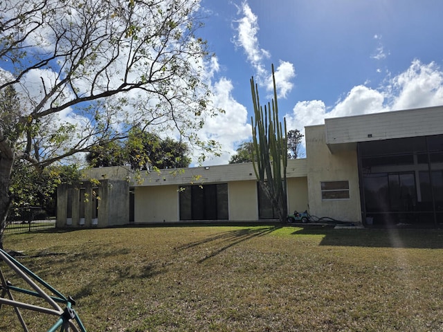 back of house with a lawn and fence