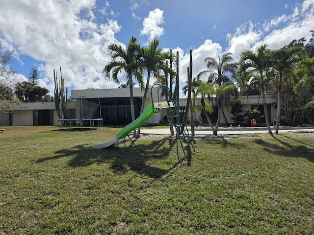 community jungle gym with a trampoline and a lawn