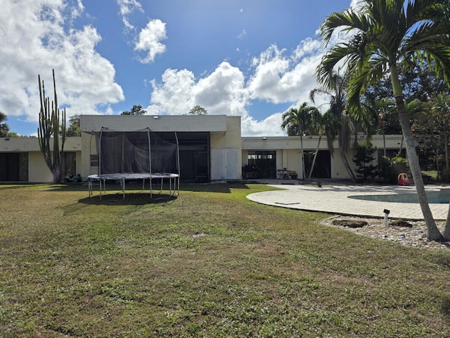 view of yard with a swimming pool, a patio area, and a trampoline