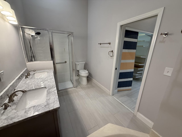 bathroom featuring an enclosed shower, vanity, toilet, and wood-type flooring