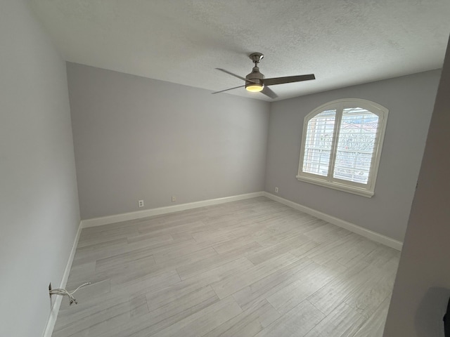 unfurnished room featuring ceiling fan, light hardwood / wood-style floors, and a textured ceiling