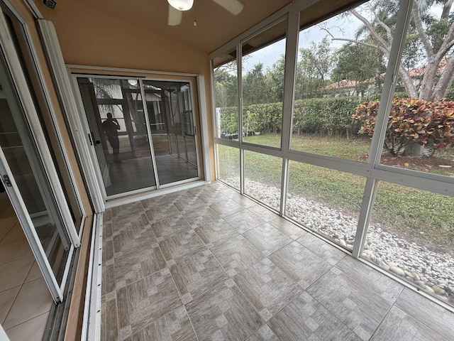 unfurnished sunroom with ceiling fan and lofted ceiling