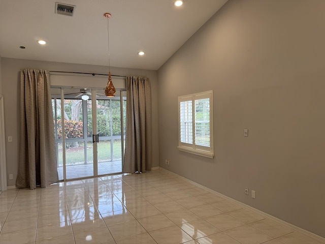 empty room featuring high vaulted ceiling and light tile patterned floors