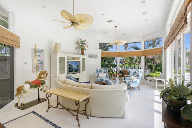 living room with ceiling fan, plenty of natural light, and crown molding