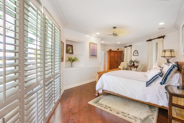 bedroom with dark wood-style flooring, a wainscoted wall, ornamental molding, and recessed lighting