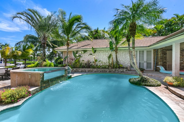 view of swimming pool featuring a patio area, an in ground hot tub, french doors, and pool water feature