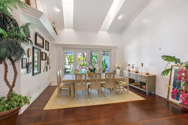 dining area with a towering ceiling and dark hardwood / wood-style floors