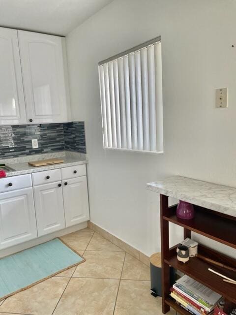 kitchen with decorative backsplash, white cabinetry, and light tile patterned floors