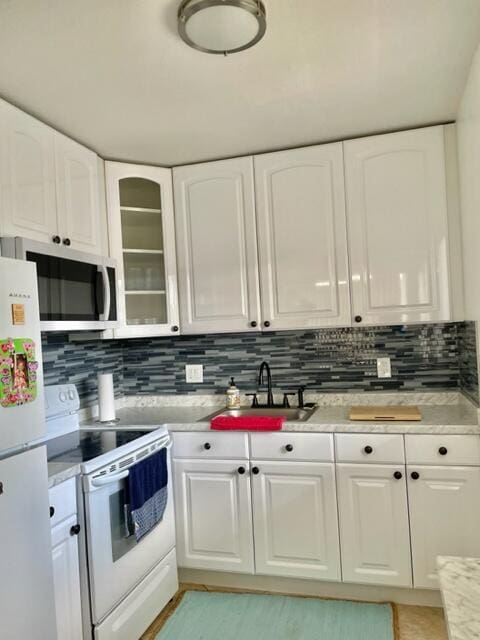 kitchen featuring white cabinets, decorative backsplash, white appliances, and sink