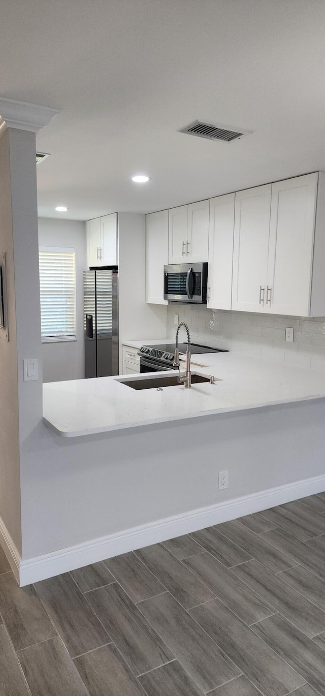 kitchen with stainless steel appliances, white cabinetry, dark hardwood / wood-style floors, and sink