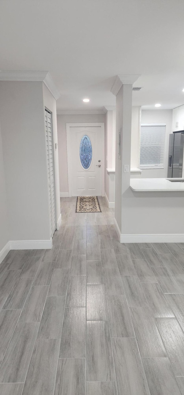 hallway with crown molding and light hardwood / wood-style floors