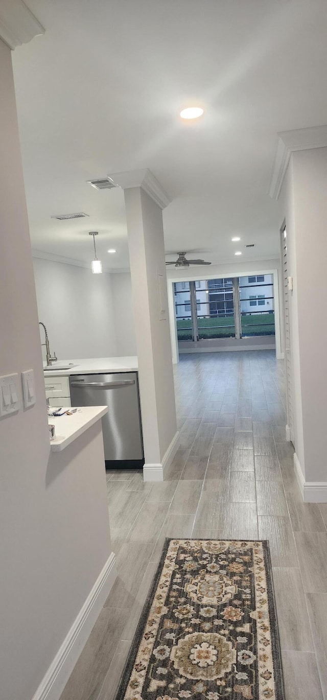 hallway featuring sink, ornamental molding, and light wood-type flooring