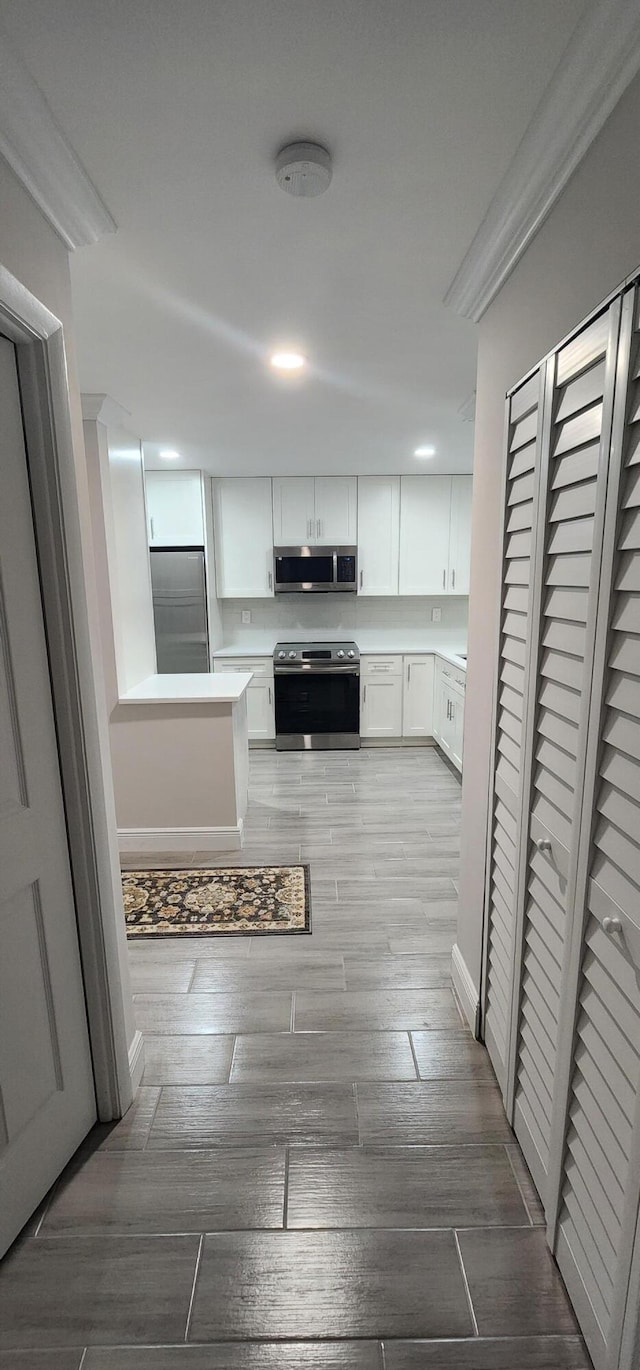 kitchen with white cabinets, stainless steel appliances, and wood-type flooring