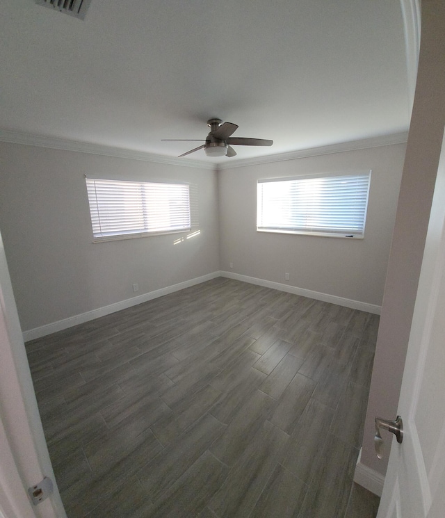 empty room with dark hardwood / wood-style floors, ceiling fan, and crown molding