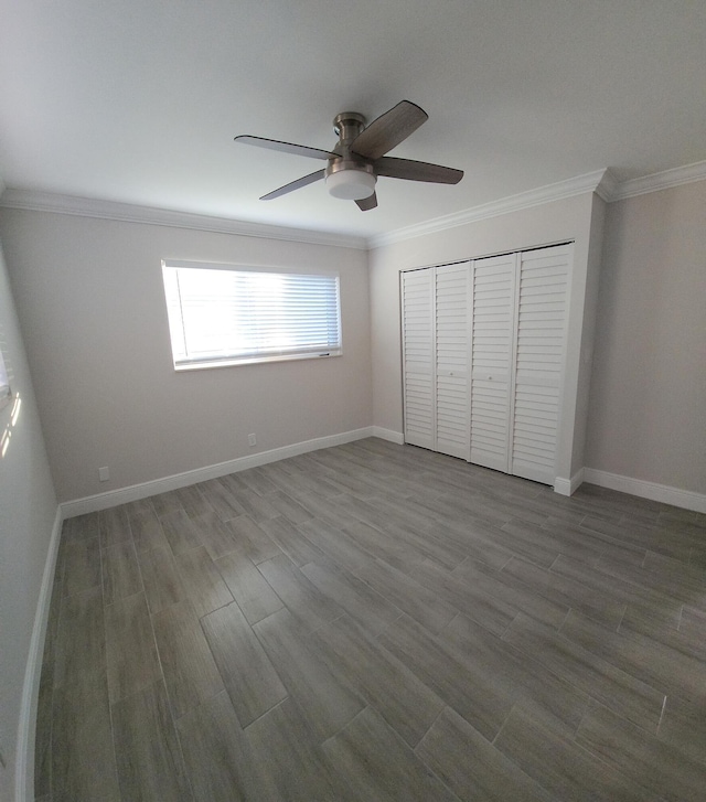 unfurnished bedroom featuring hardwood / wood-style floors, ceiling fan, ornamental molding, and a closet