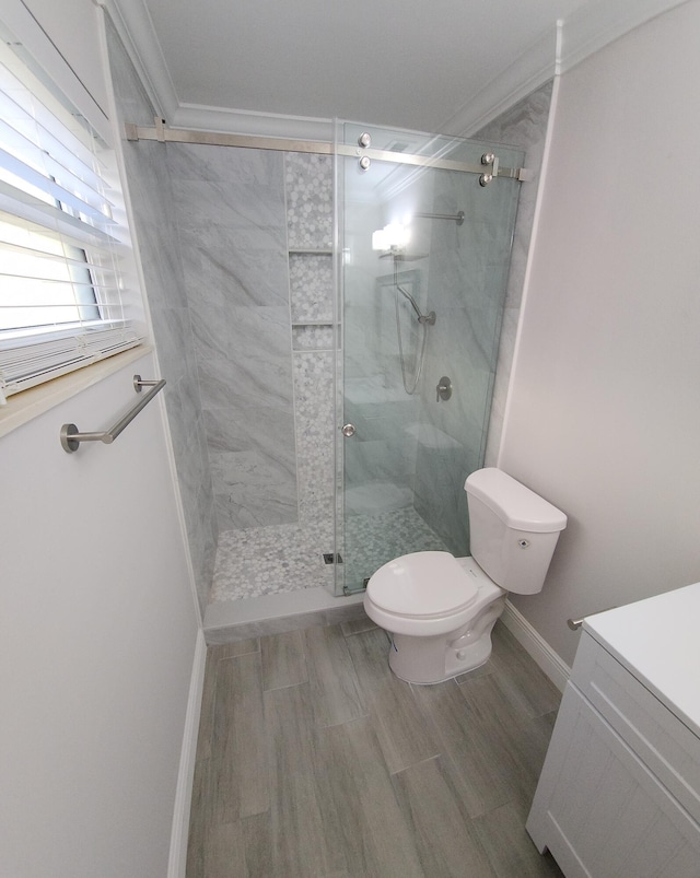 bathroom with vanity, toilet, an enclosed shower, and ornamental molding