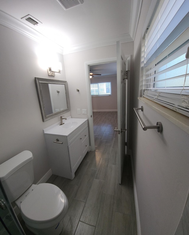 bathroom with vanity, crown molding, ceiling fan, toilet, and wood-type flooring