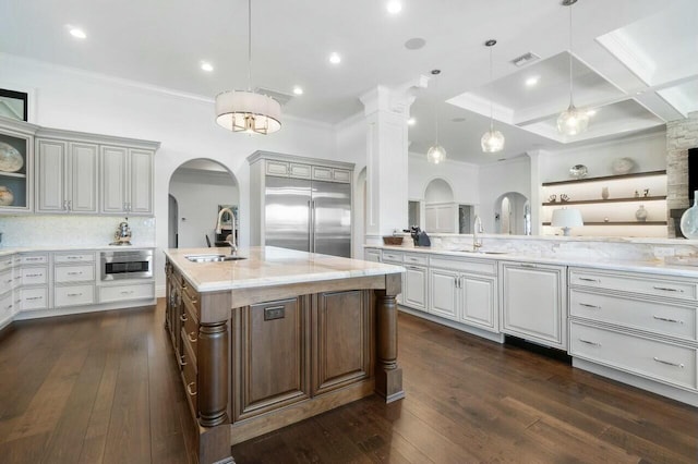 kitchen with sink, hanging light fixtures, coffered ceiling, a large island with sink, and stainless steel built in fridge