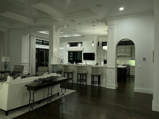 living room with beamed ceiling, ornamental molding, and dark wood-type flooring