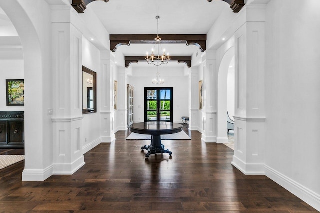 foyer entrance featuring french doors, dark hardwood / wood-style flooring, decorative columns, beam ceiling, and a notable chandelier