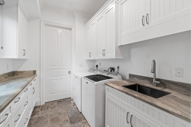 laundry area featuring washer and dryer, sink, cabinets, and ornamental molding