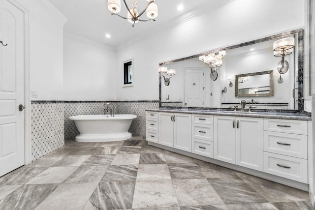 bathroom with a washtub, vanity, crown molding, and a notable chandelier