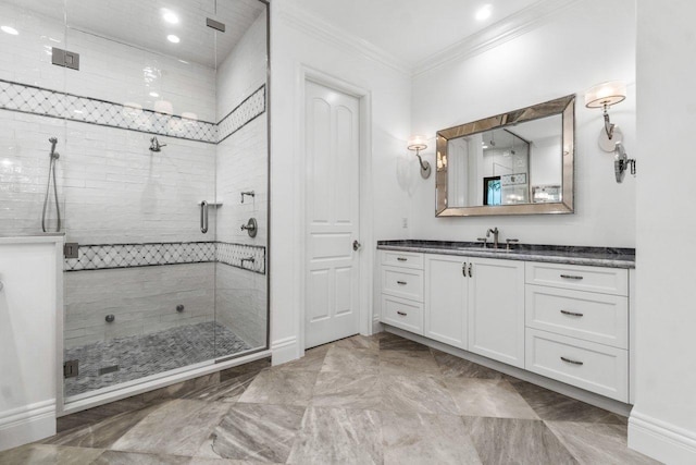 bathroom with vanity, a shower with shower door, and crown molding