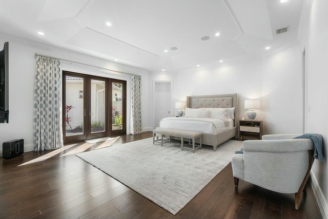 bedroom featuring french doors, a raised ceiling, and wood-type flooring