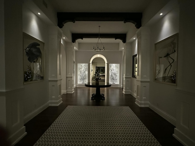 hallway with beam ceiling and ornate columns