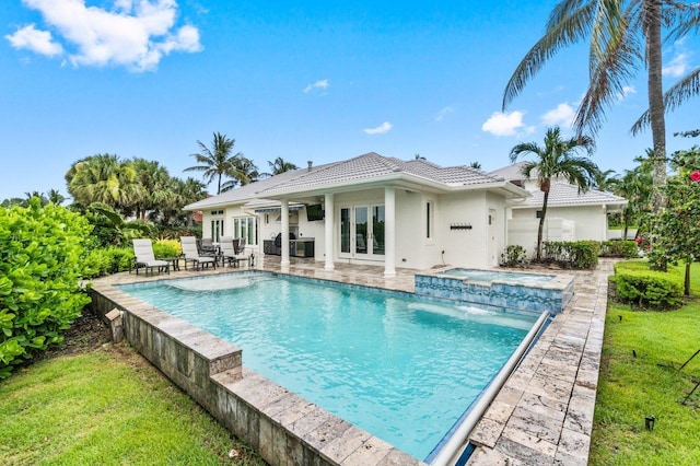 view of pool featuring an in ground hot tub, pool water feature, and a patio