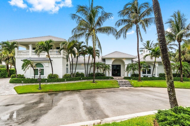 mediterranean / spanish-style house with a balcony and a front yard