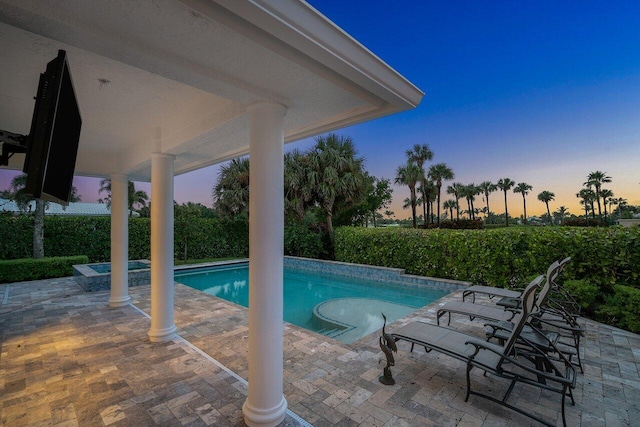 pool at dusk featuring a patio area