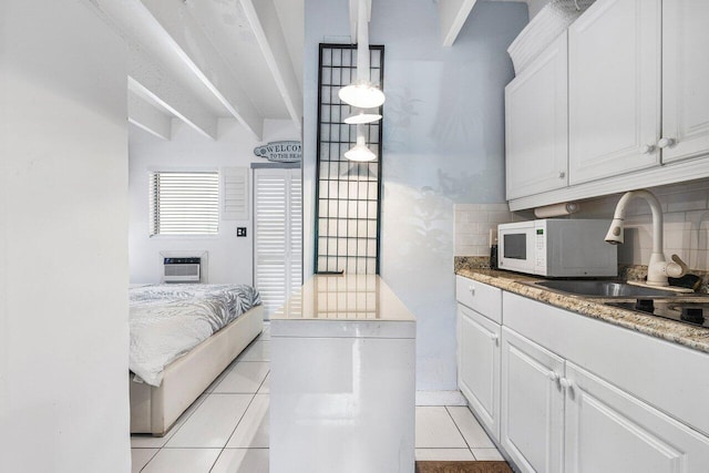 interior space with white cabinetry, sink, beamed ceiling, and light tile patterned floors