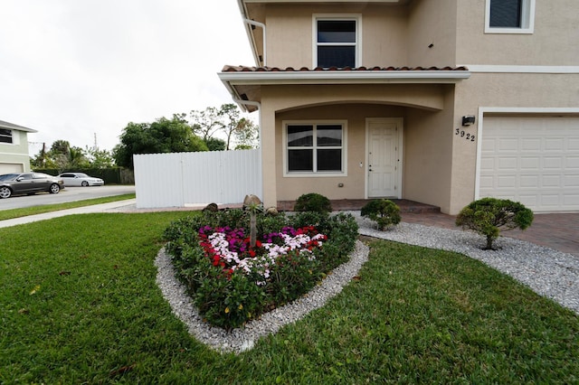 doorway to property featuring a lawn and a garage