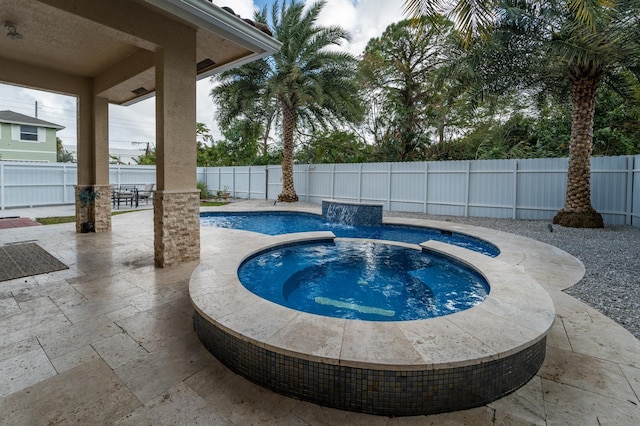 view of swimming pool with an in ground hot tub, pool water feature, and a patio area