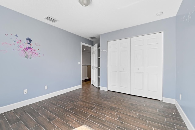 unfurnished bedroom with dark hardwood / wood-style floors and a closet