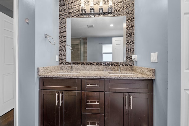 bathroom with hardwood / wood-style flooring, vanity, and tasteful backsplash