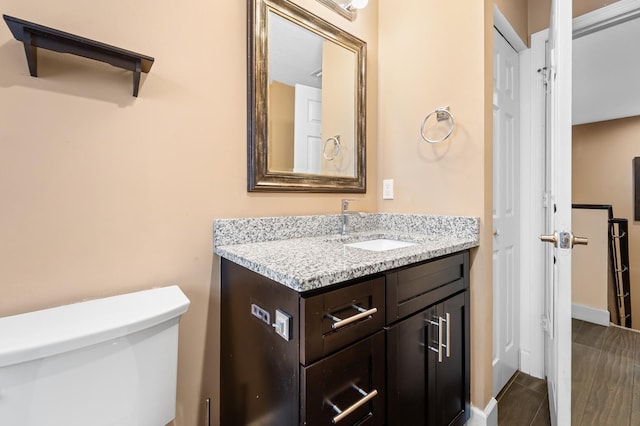 bathroom featuring hardwood / wood-style flooring, vanity, and toilet